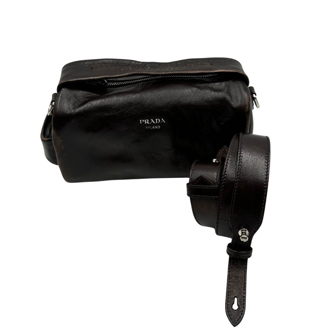 Borsa Prada in pelle marrone effetto distressed con parti metalliche argentate; munita di un manico singolo e una tracolla amovibile e regolabile. Completa di scatola, di lusso, originale, ottime condizioni. 