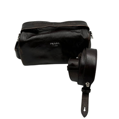 Borsa Prada in pelle marrone effetto distressed con parti metalliche argentate; munita di un manico singolo e una tracolla amovibile e regolabile. Completa di scatola, di lusso, originale, ottime condizioni. 