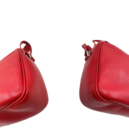 Angoli, Borsa Saint Laurent in pelle rossa con hardware argentato decorativo, iconiche iniziali YSL al centro e nappa decorativa. Indossabile a tracolla. Originale, usata, di lusso, in ottime condizioni.