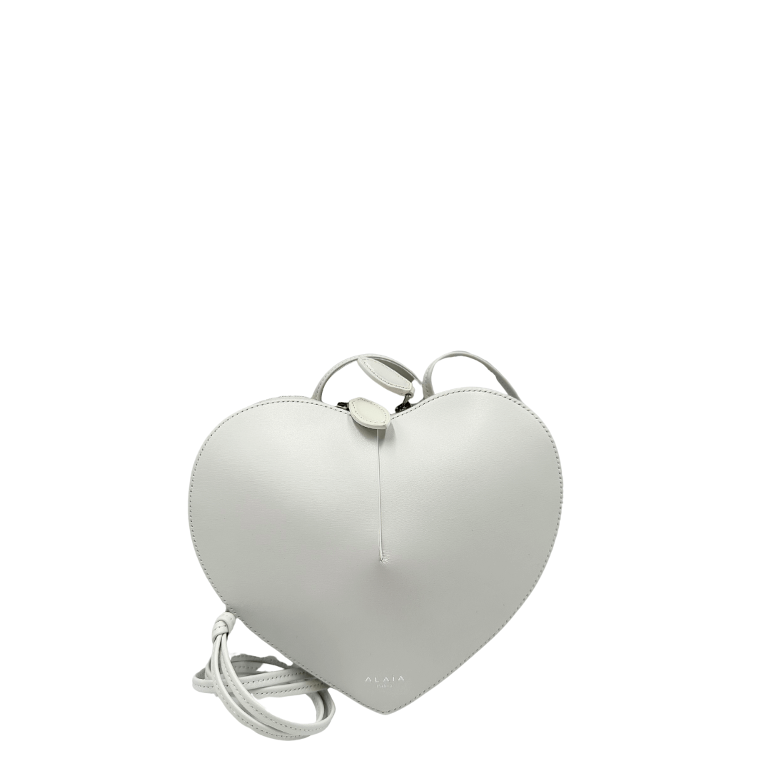 Alaïa Le Coeur: borsa iconica a forma di cuore in pelle bianca, raffinata e unica nel suo design romantico, perfetta per un look elegante e moderno.