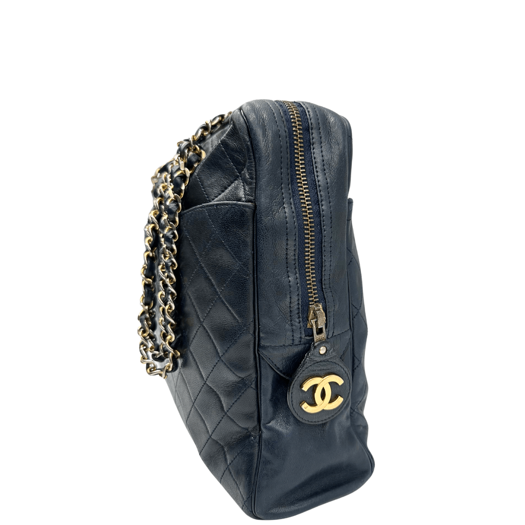 Borsa a spalla Chanel in pelle trapuntata blu con dettagli iconici. Caratterizzata dalla catena intrecciata con inserti in pelle e dalla classica chiusura con logo CC in metallo dorato, incarna eleganza e stile senza tempo. Perfetta per un look sofisticato e di classe.