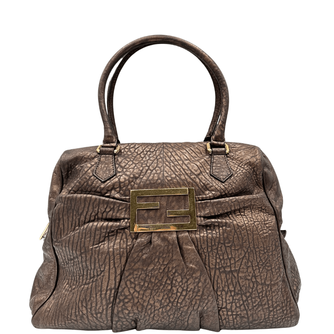 Scopri la shopper Fendi in pelle bronzo con l'iconico logo in metallo dorato. Eleganza e stile in un design spazioso e versatile.