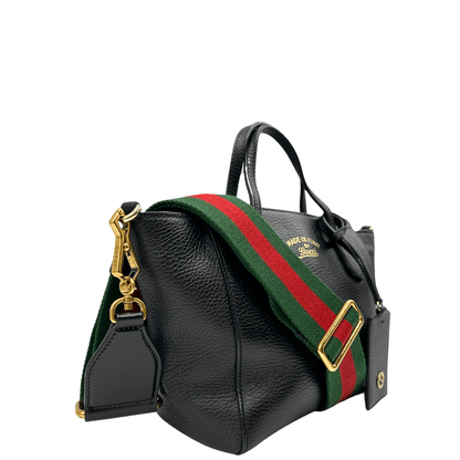 Gucci Swing Mini: elegante borsa in pelle nera con tracolla a righe rosse e verdi. Perfetta per un look sofisticato e pratico.