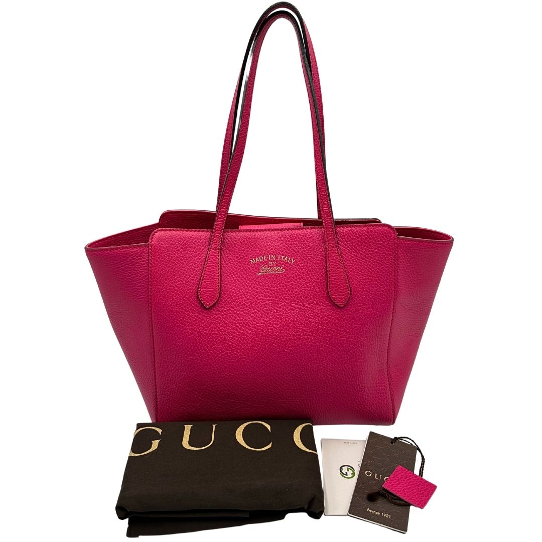 Borsa Gucci in pelle martellata fucsia rifinita con inserti metallici dorati; dotata di doppi manici, indossabile a spalla, dustbag 