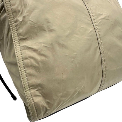 angolo Borsa Burberry in nylon color sabbia rifinita con parti in pelle nere e inserti metallici effetto renio; munita di doppi manici, da indossare a spalla 