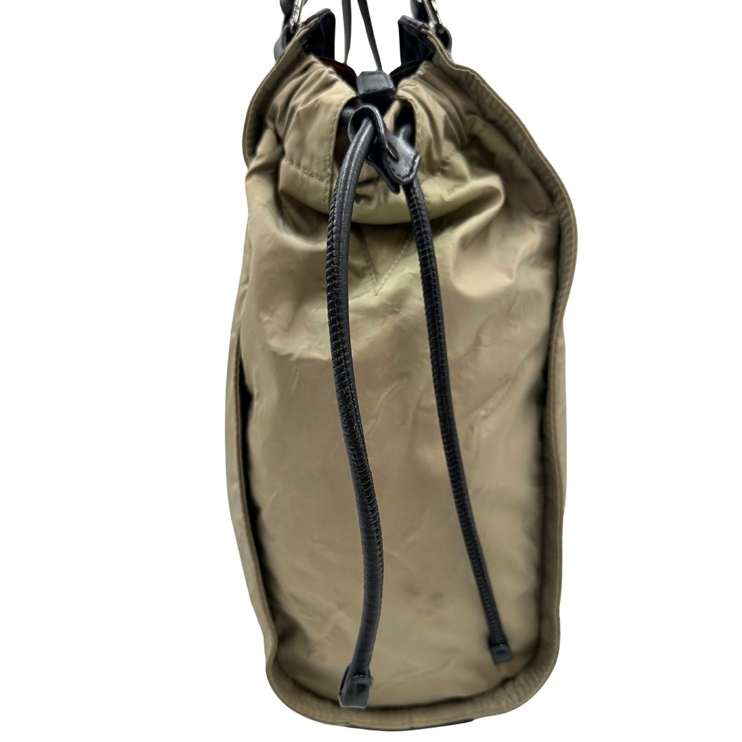 lato Borsa Burberry in nylon color sabbia rifinita con parti in pelle nere e inserti metallici effetto renio; munita di doppi manici, da indossare a spalla 