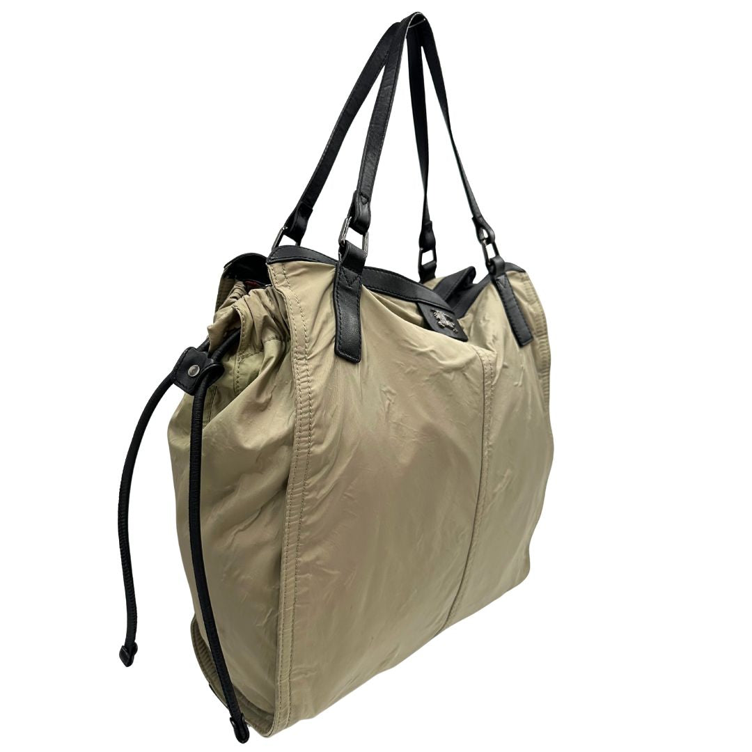 lato Borsa Burberry in nylon color sabbia rifinita con parti in pelle nere e inserti metallici effetto renio; munita di doppi manici, da indossare a spalla 