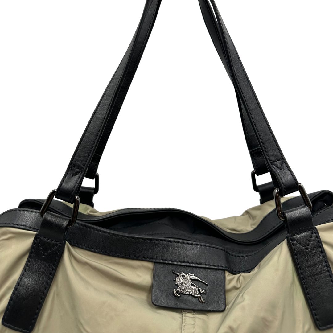 Borsa Burberry in nylon color sabbia rifinita con parti in pelle nere e inserti metallici effetto renio; munita di doppi manici, da indossare a spalla 