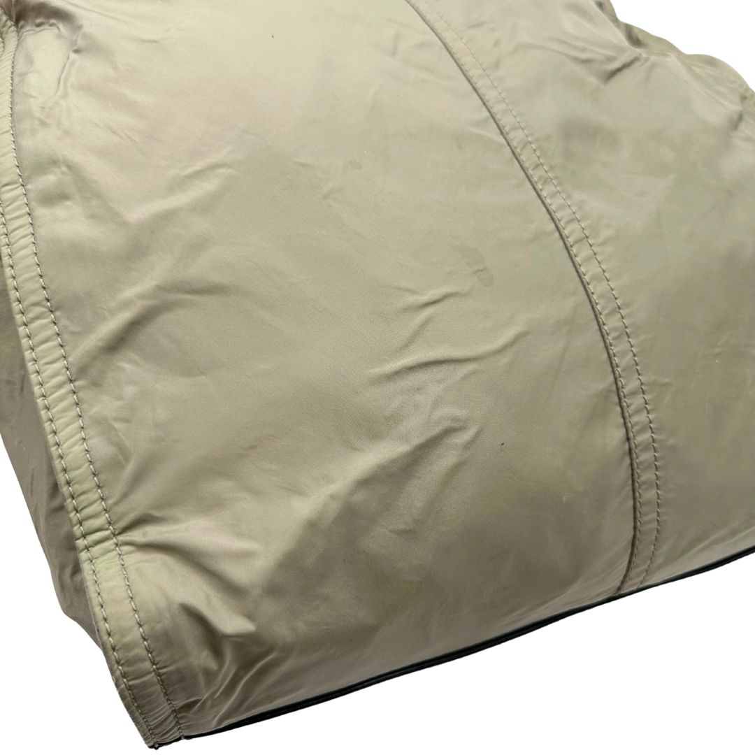 angolo Borsa Burberry in nylon color sabbia rifinita con parti in pelle nere e inserti metallici effetto renio; munita di doppi manici, da indossare a spalla 