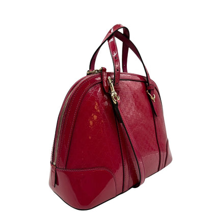 lato Borsa Gucci in pelle verniciata rosso fragola rifinita con inserti metallici oro chiaro; munita di doppi manici e una tracolla regolabile e amovibile 