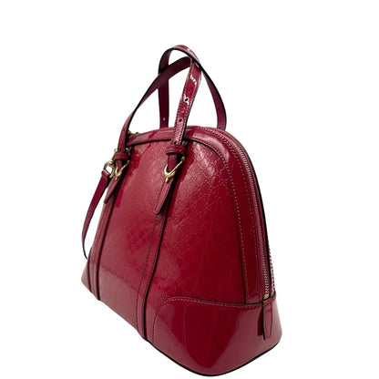 lato Borsa Gucci in pelle verniciata rosso fragola rifinita con inserti metallici oro chiaro; munita di doppi manici e una tracolla regolabile e amovibile 