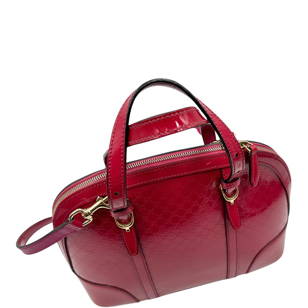 Borsa Gucci in pelle verniciata rosso fragola rifinita con inserti metallici oro chiaro; munita di doppi manici e una tracolla regolabile e amovibile 