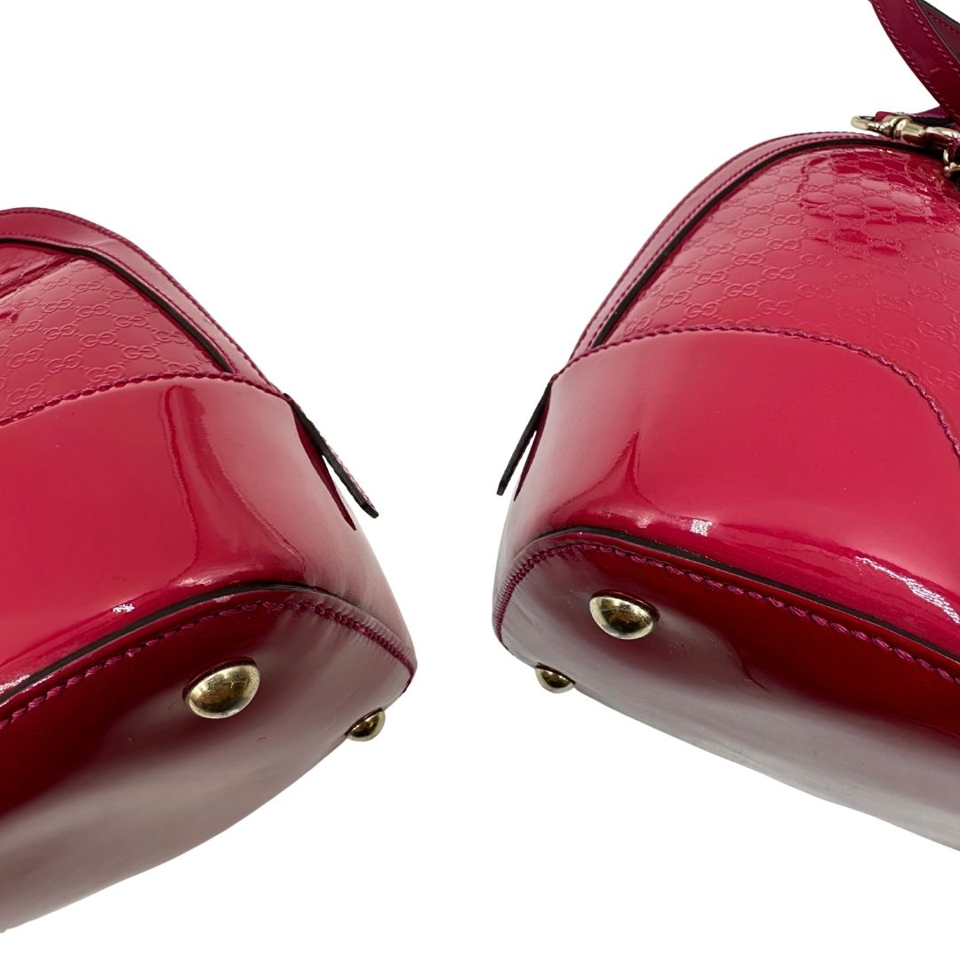 angoli  Borsa Gucci in pelle verniciata rosso fragola rifinita con inserti metallici oro chiaro; munita di doppi manici e una tracolla regolabile e amovibile 