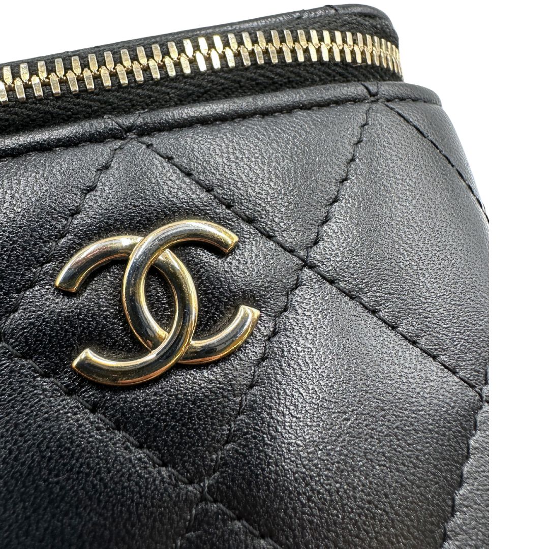 Difetto di una borsa Chanel in pelle matelassè nera rifinita con parti metalliche dorate; munita di una tracolla in pelle e catena intrecciata decorata con fiocco e camelia. Completa di scatola logata.