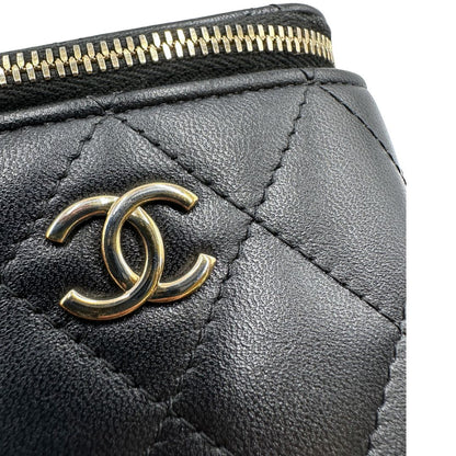 Difetto di una borsa Chanel in pelle matelassè nera rifinita con parti metalliche dorate; munita di una tracolla in pelle e catena intrecciata decorata con fiocco e camelia. Completa di scatola logata.