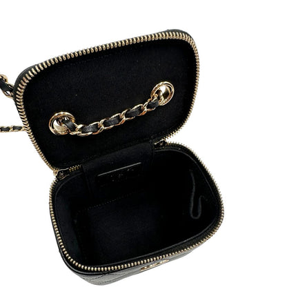 Interno di una borsa Chanel in pelle matelassè nera rifinita con parti metalliche dorate; munita di una tracolla in pelle e catena intrecciata decorata con fiocco e camelia. Completa di scatola logata.