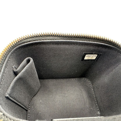 Interno di una borsa Chanel in pelle matelassè nera rifinita con parti metalliche dorate; munita di una tracolla in pelle e catena intrecciata decorata con fiocco e camelia. Completa di scatola logata.