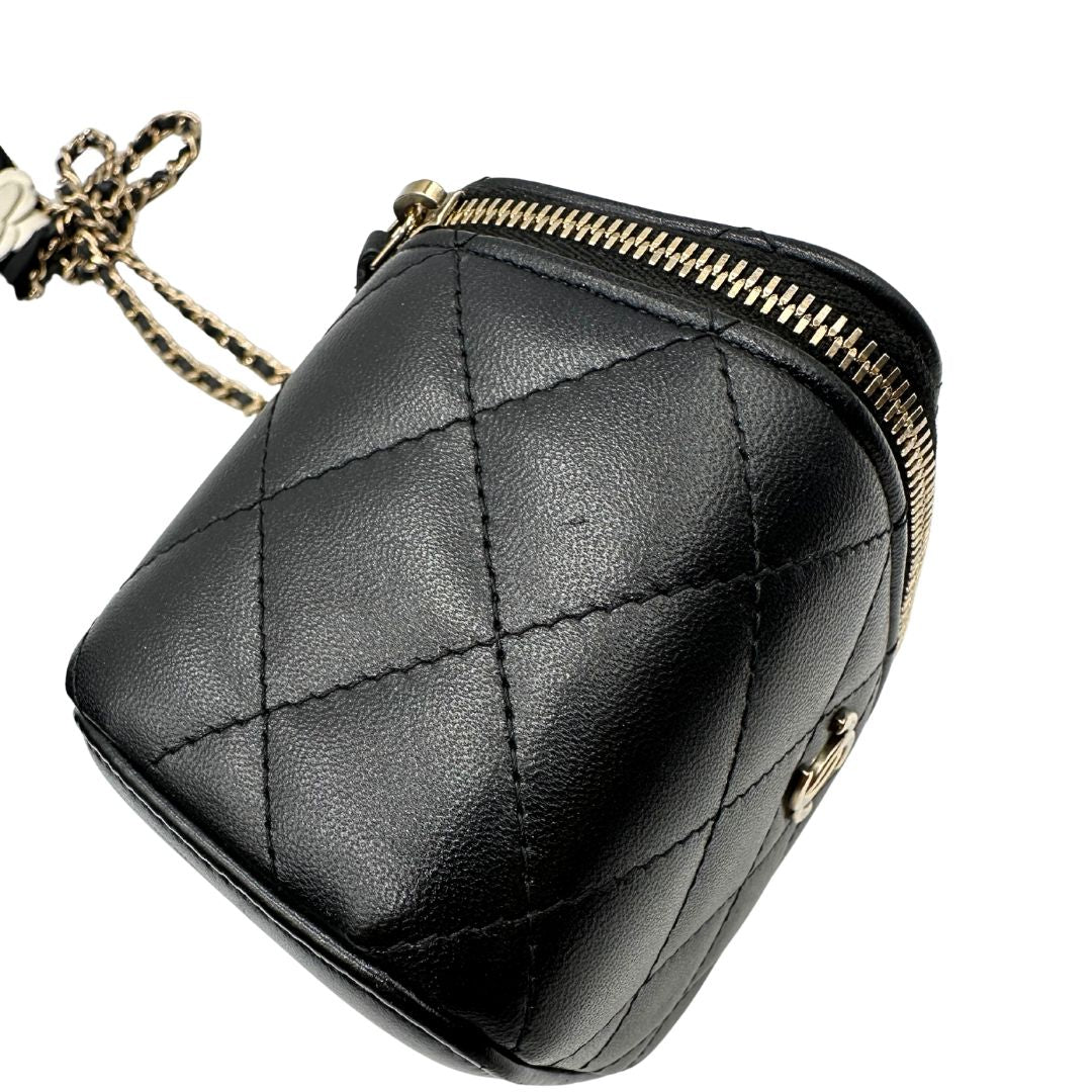 Difetto di una borsa Chanel in pelle matelassè nera rifinita con parti metalliche dorate; munita di una tracolla in pelle e catena intrecciata decorata con fiocco e camelia. Completa di scatola logata.