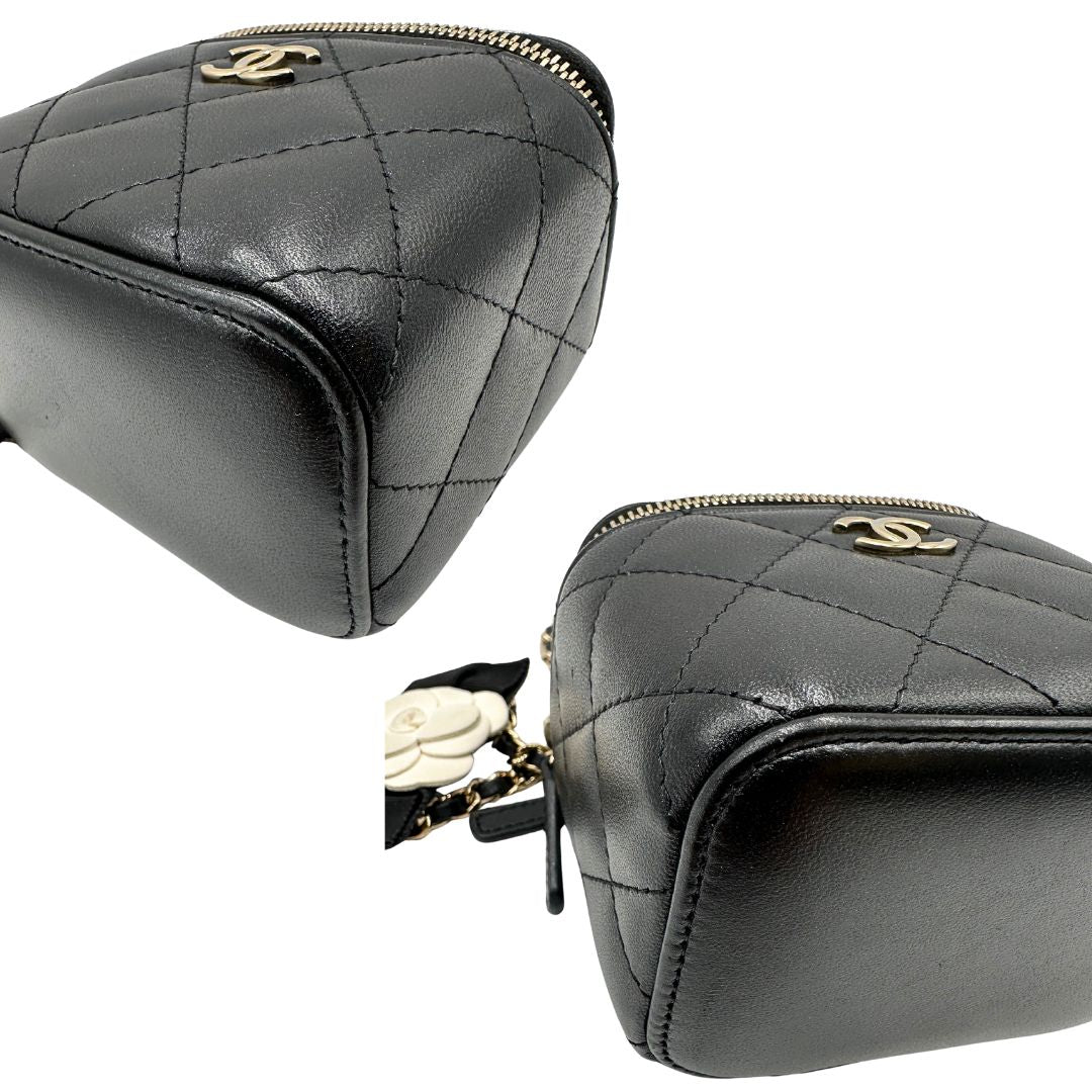 Angoli di una borsa Chanel in pelle matelassè nera rifinita con parti metalliche dorate; munita di una tracolla in pelle e catena intrecciata decorata con fiocco e camelia. Completa di scatola logata.