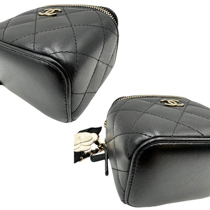 Angoli di una borsa Chanel in pelle matelassè nera rifinita con parti metalliche dorate; munita di una tracolla in pelle e catena intrecciata decorata con fiocco e camelia. Completa di scatola logata.