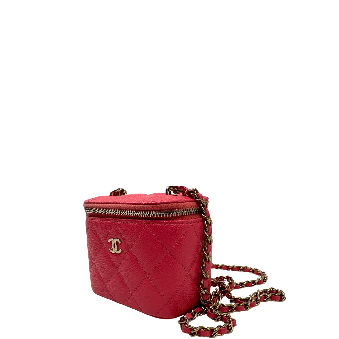 Laterale destro di una borsa Chanel in pelle matelassè rosa fragola rifinita con parti metalliche dorate; munita di una tracolla in pelle e catena intrecciata. Completa di specchietto interno e scatola logata.