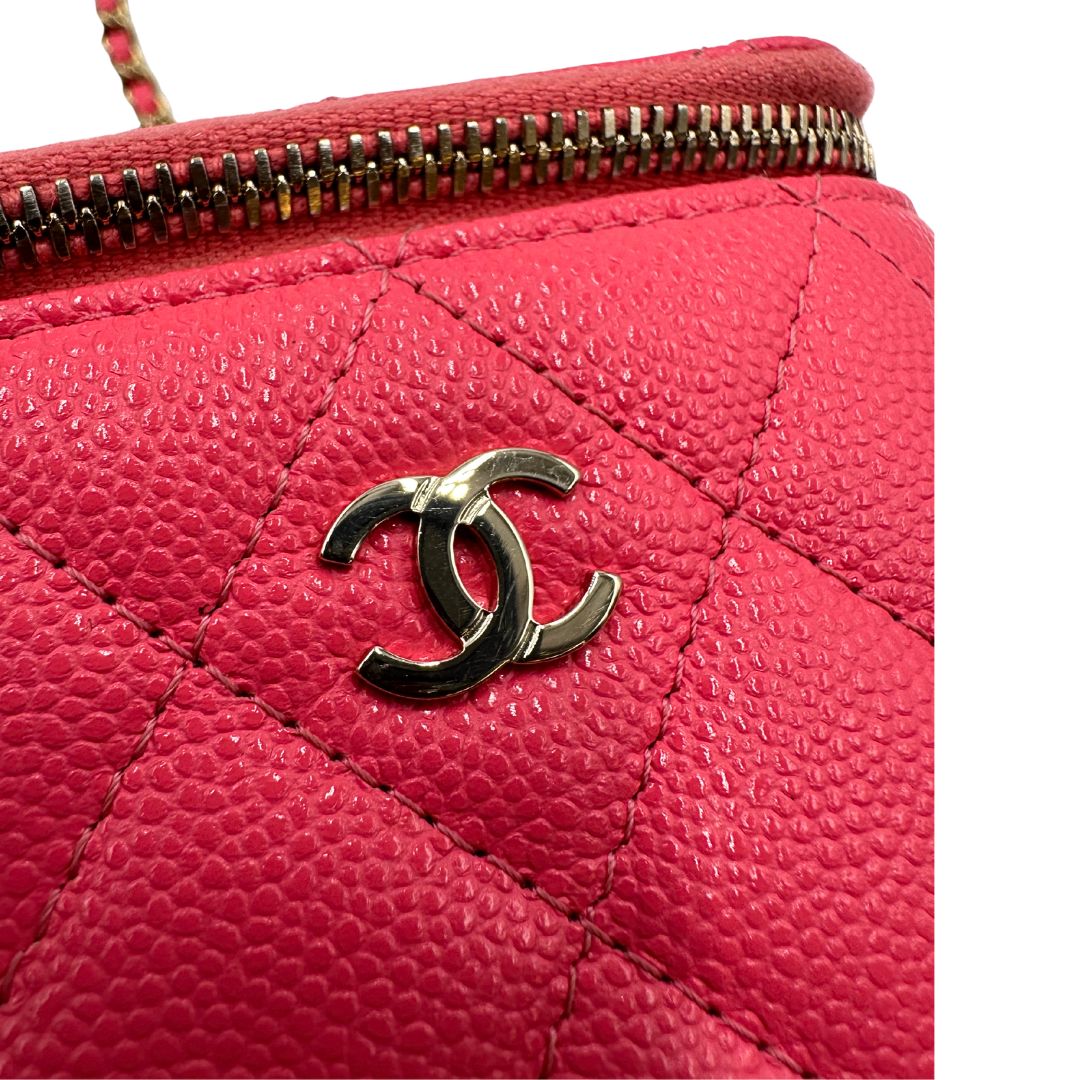 Dettaglio del logo di una borsa Chanel in pelle matelassè rosa fragola rifinita con parti metalliche dorate; munita di una tracolla in pelle e catena intrecciata. Completa di specchietto interno e scatola logata.