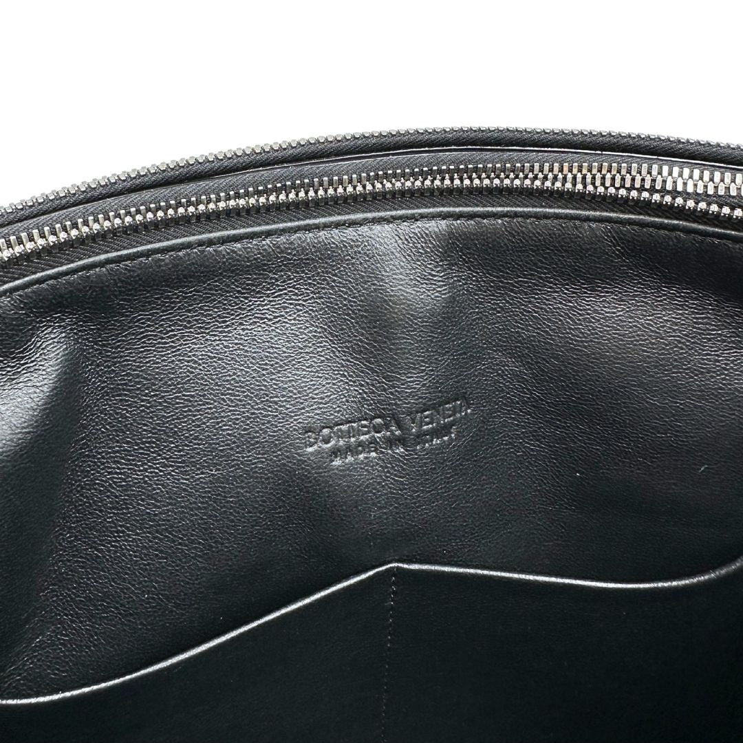 Interno Cartella Bottega Veneta in pelle intrecciata nera, rifinita con inserti metallici argentati e munita di una tracolla regolabile