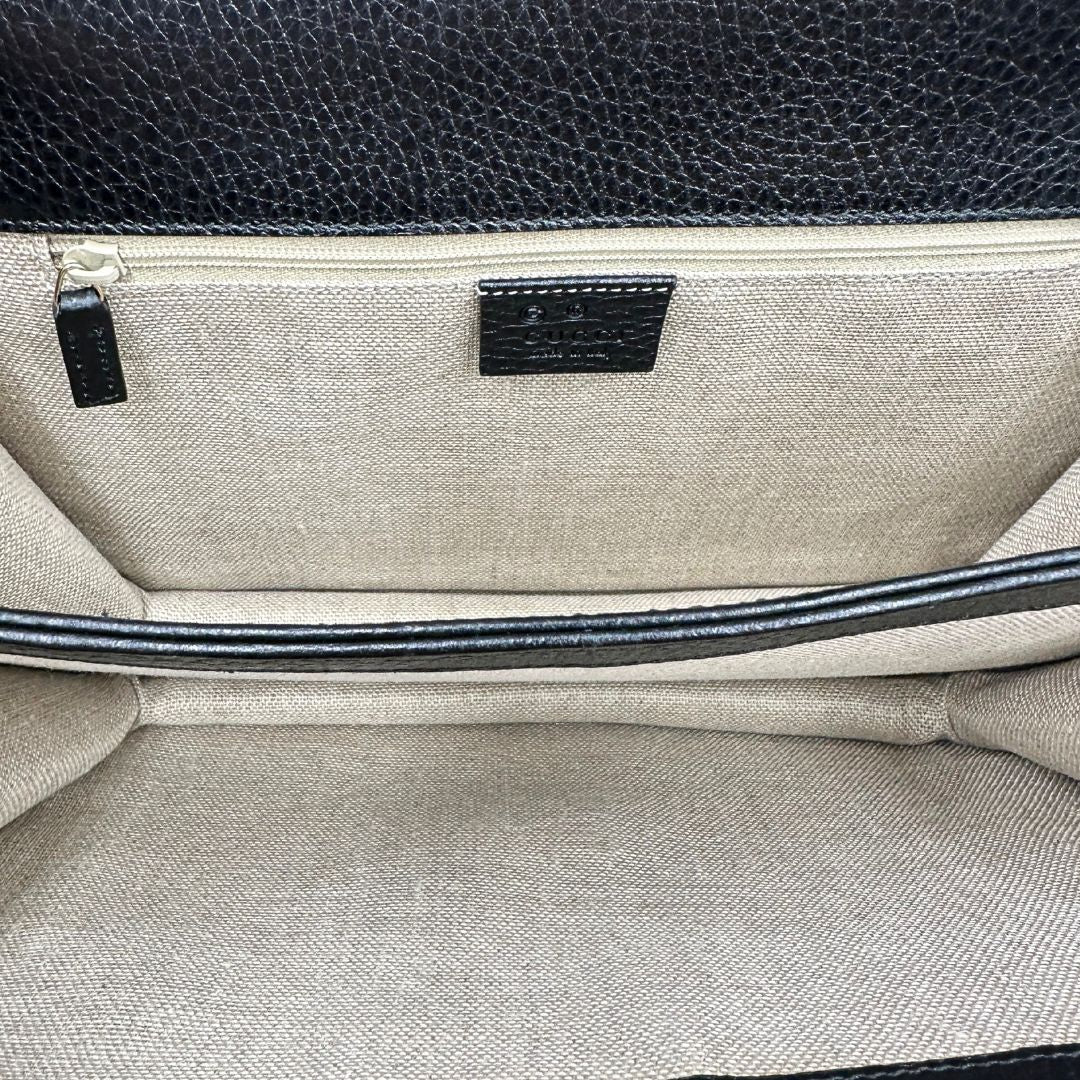 Borsa Gucci in pelle martellata nera rifinita con inserti metallici dorati; munita di una tracolla in catena scorrevole con spallaccio in pelle interno 