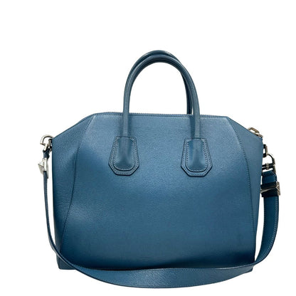 Borsa Givenchy Antigona in pelle martellata blu petrolio munita di doppi manici stondati e tracolla. Parti metalliche argentate. Completa di dustbag. Originale, usato, in condizioni ottime. 