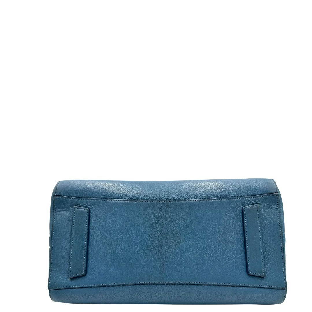 Borsa Givenchy Antigona in pelle martellata blu petrolio munita di doppi manici stondati e tracolla. Parti metalliche argentate. Completa di dustbag. Originale, usato, in condizioni ottime. 