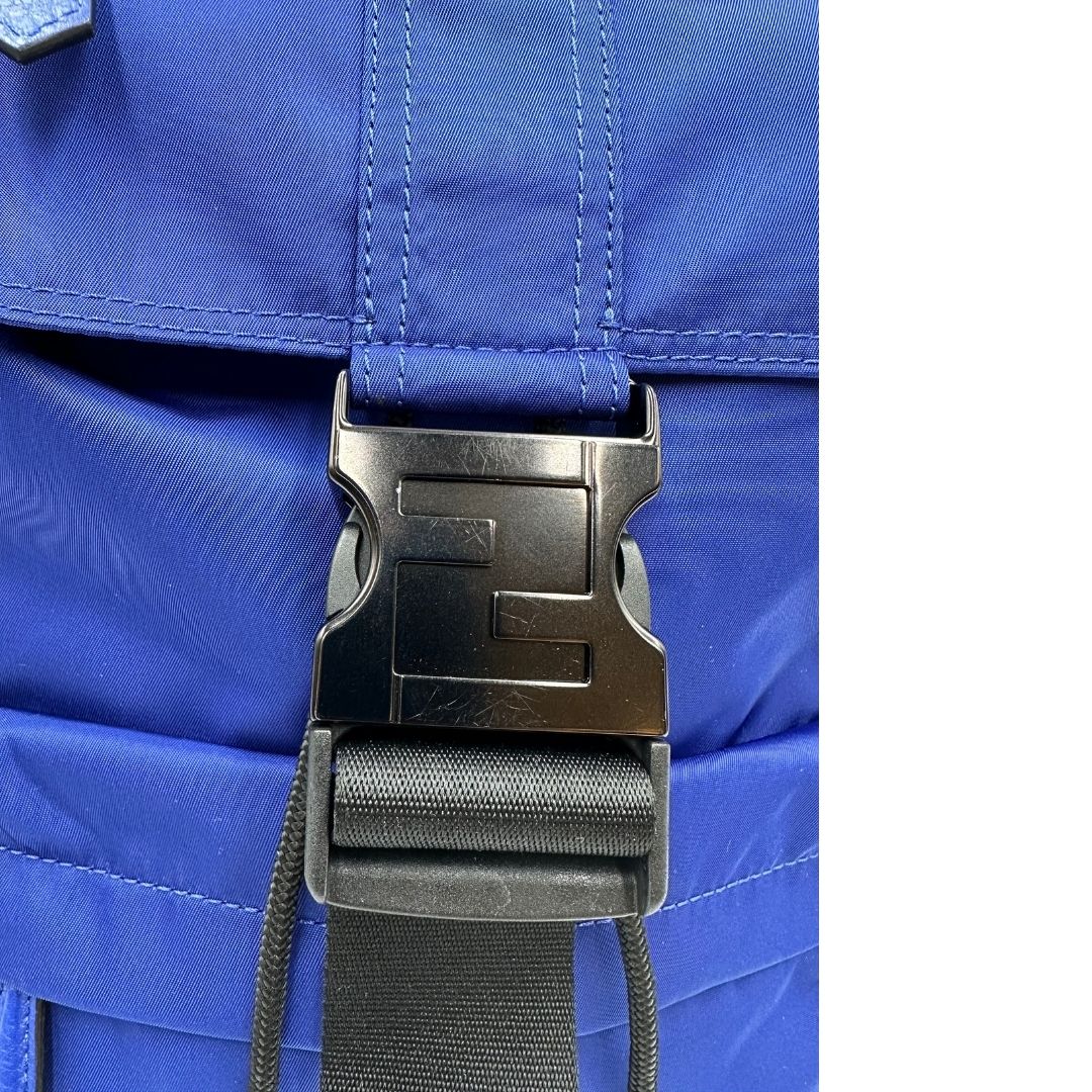 Gancio di chiusura di uno zaino Fendi edizione limitata in Econyl di Aquafil blu reale rifinito con parti in pelle tono su tono; munito di una bretella regolabile. Retro traforato trama zucca in nero. Completo di dustbag e cartellino.