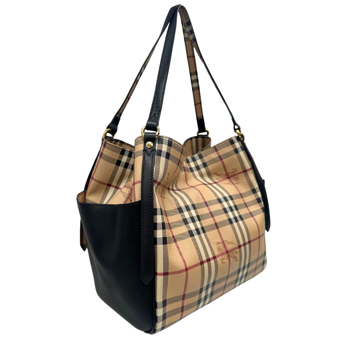 Laterale sinistro di una borsa Burberry in canvas beige trama Burberry Check, con finiture in pelle nere e parti metalliche dorate. Munita di dustbag.