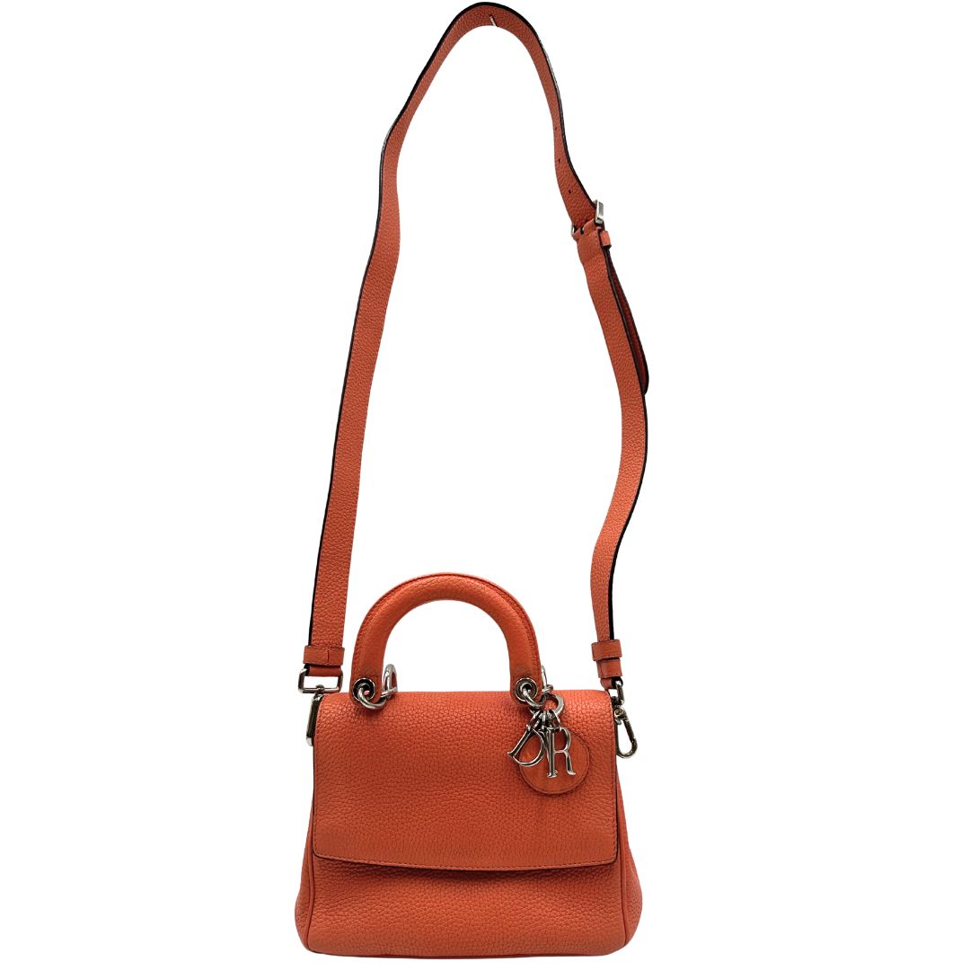 Borsa Christian Dior Bedior in pelle corallo. Manico rigido e tracolla amovibile e regolabile. Parti metalliche argentate.