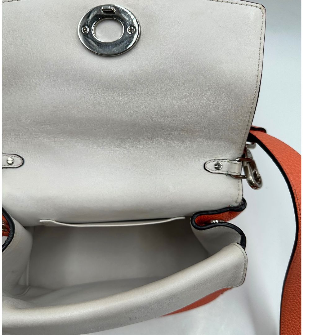 Interno di una borsa Christian Dior Bedior in pelle corallo. Manico rigido e tracolla amovibile e regolabile. Parti metalliche argentate.