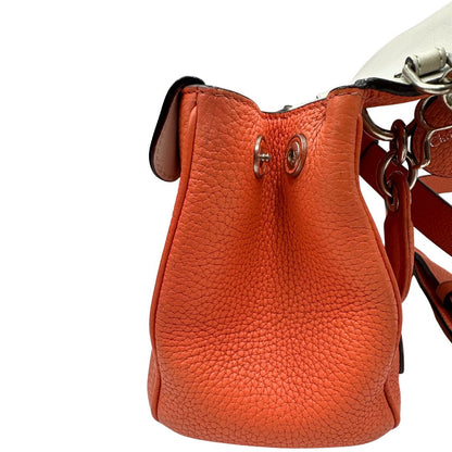 Vista laterale di una borsa Christian Dior Bedior in pelle corallo. Manico rigido e tracolla amovibile e regolabile. Parti metalliche argentate.