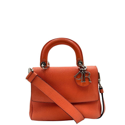 Front di una borsa Christian Dior Bedior in pelle corallo. Manico rigido e tracolla amovibile e regolabile. Parti metalliche argentate.