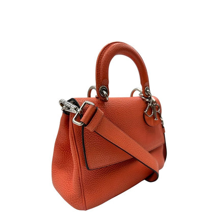 Laterale sinistro di una borsa Christian Dior Bedior in pelle corallo. Manico rigido e tracolla amovibile e regolabile. Parti metalliche argentate.