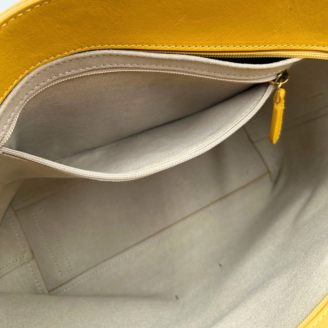 interno Borsa The Bridge in pelle gialla con parti metalliche dorate; munita di doppi manici, da indossare a spalla 