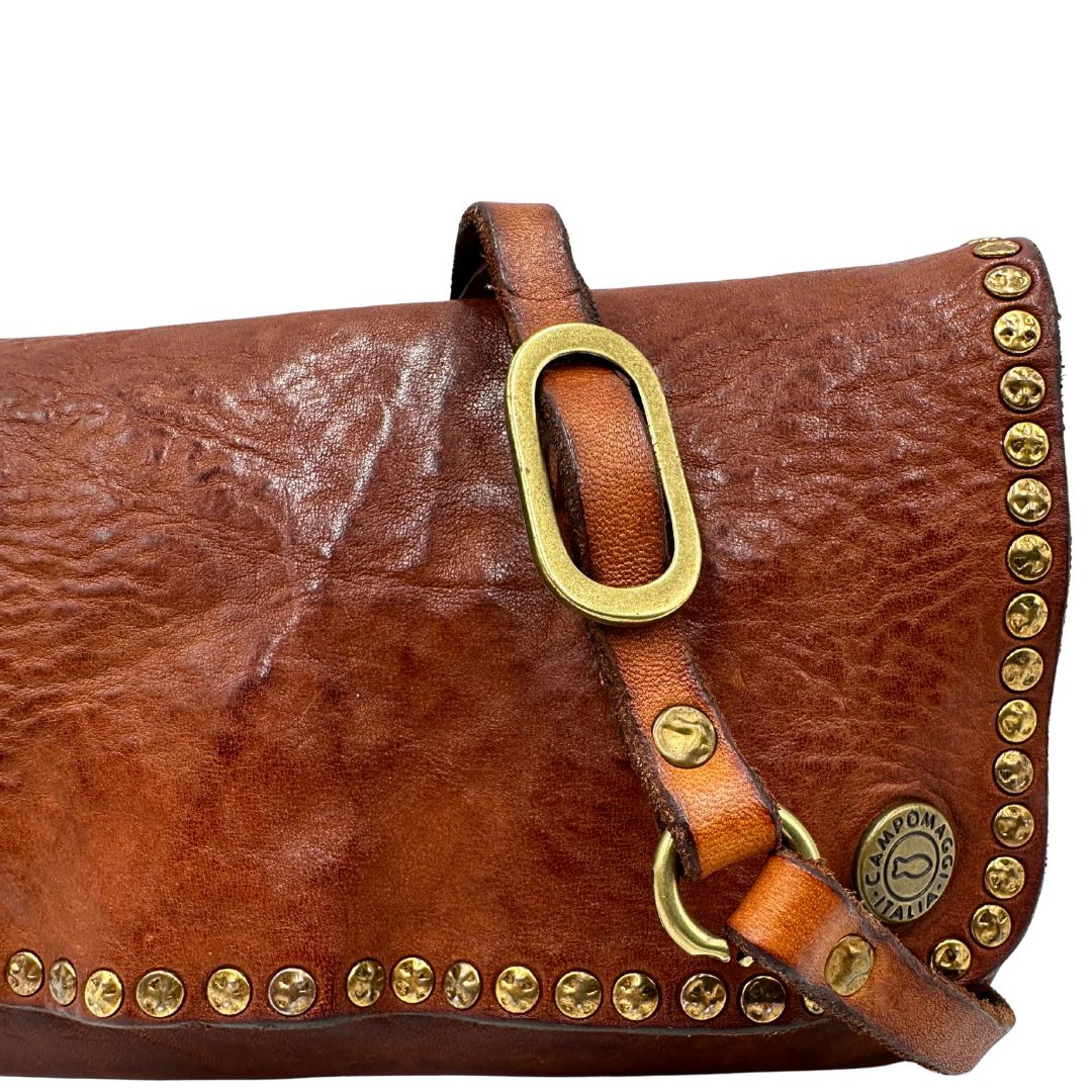 Borsa Campomaggi in cuoio impreziosita da borchie in metallo dorato e munita di una tracolla regolabile, e amovibile. Completa di dustbag e cartellino. Originale, usato, in condizioni eccellenti. 
