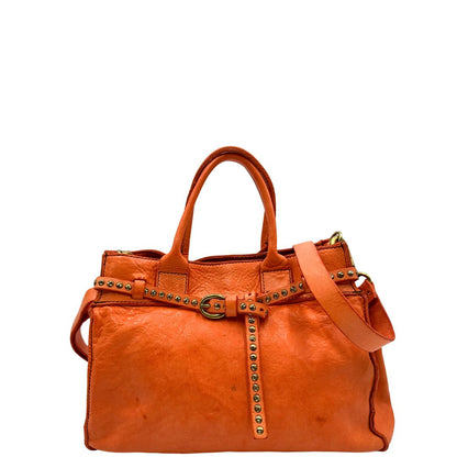 Front di una satchel Campomaggi in pelle arancione; munita di doppi manici e tracolla amovibile e regolabile. Parti metalliche dorate. Completa di dustbag e crema idratante per pelli.