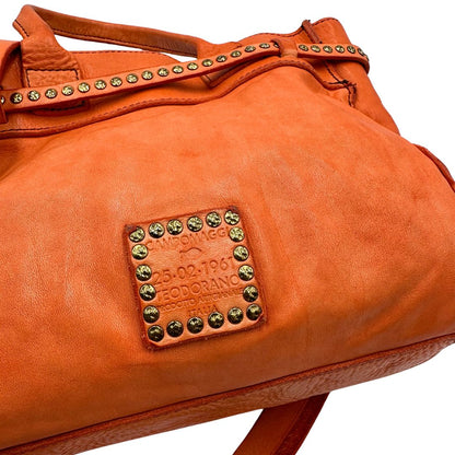 Logo di una satchel Campomaggi in pelle arancione; munita di doppi manici e tracolla amovibile e regolabile. Parti metalliche dorate. Completa di dustbag e crema idratante per pelli.