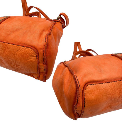 Angoli di una satchel Campomaggi in pelle arancione; munita di doppi manici e tracolla amovibile e regolabile. Parti metalliche dorate. Completa di dustbag e crema idratante per pelli.