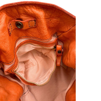 Interno di una satchel Campomaggi in pelle arancione; munita di doppi manici e tracolla amovibile e regolabile. Parti metalliche dorate. Completa di dustbag e crema idratante per pelli.