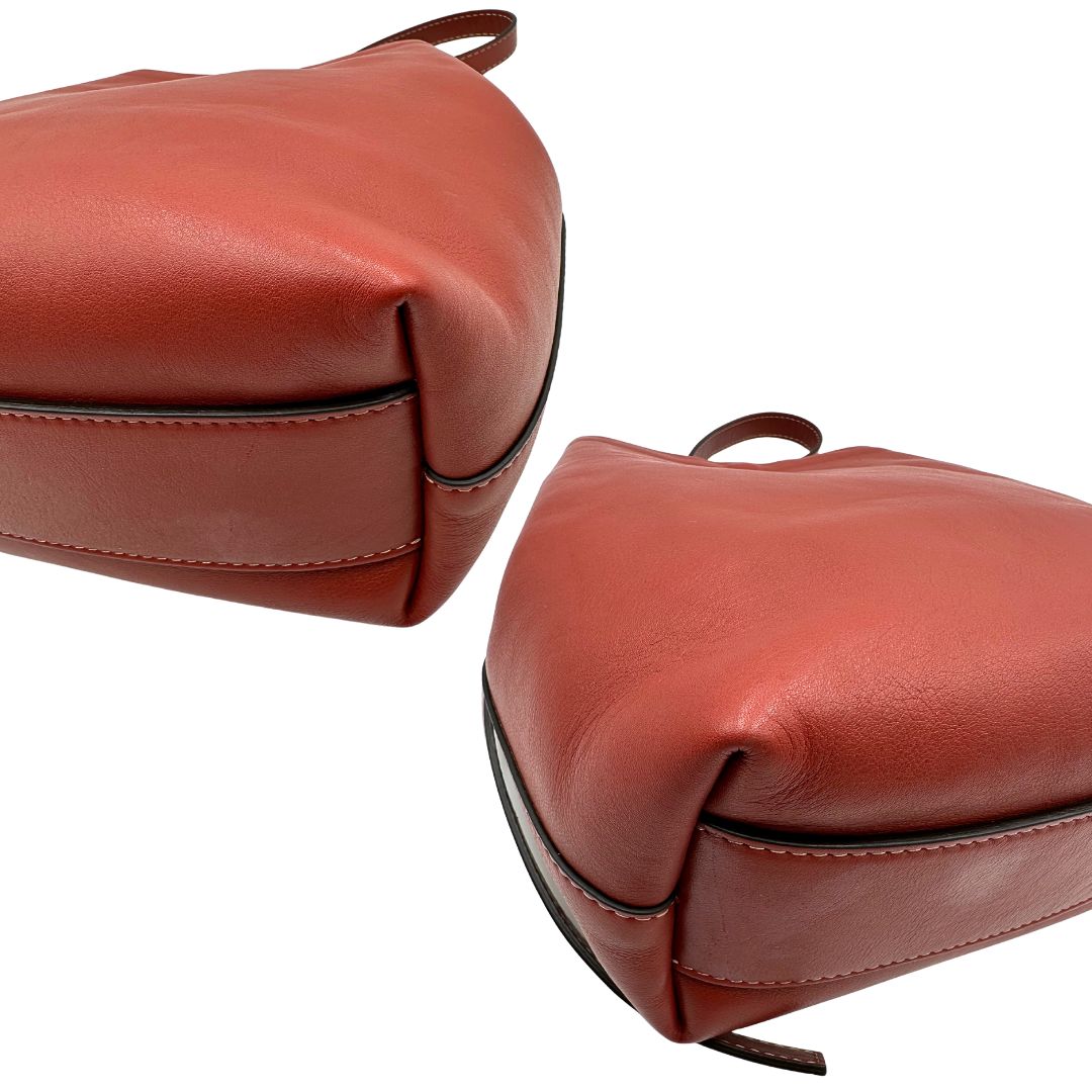 Angoli di una borsa a secchiello Hags in pelle color marrone bruciato con manico regolabile. Parti metalliche argentate. Indossabile a spalla o a tracolla. Completa di dustbag.