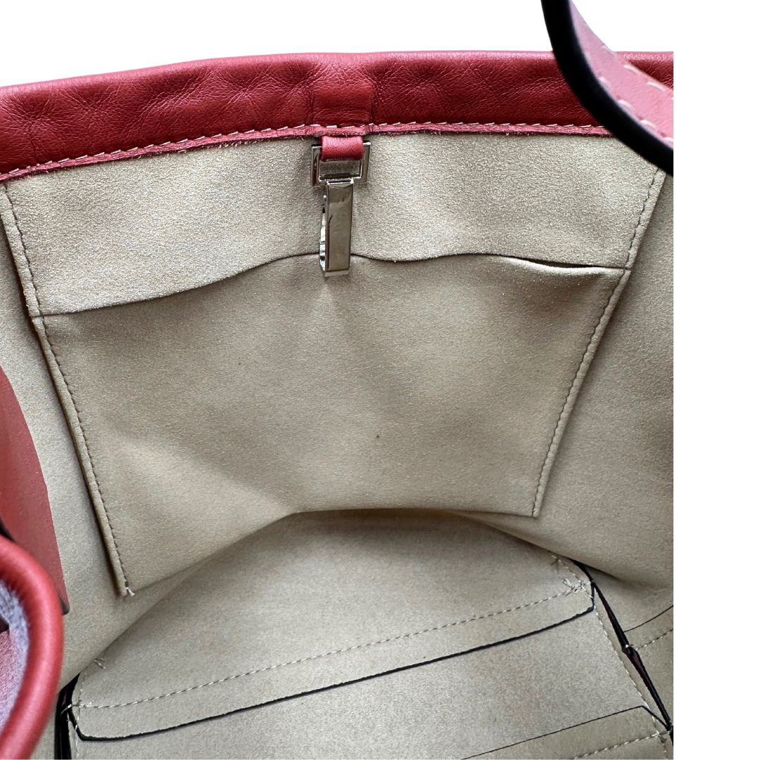 Interno di una borsa a secchiello Hags in pelle color marrone bruciato con manico regolabile. Parti metalliche argentate. Indossabile a spalla o a tracolla. Completa di dustbag.