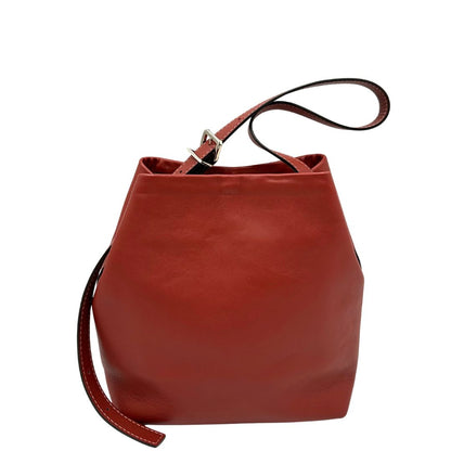 Retro di una borsa a secchiello Hags in pelle color marrone bruciato con manico regolabile. Parti metalliche argentate. Indossabile a spalla o a tracolla. Completa di dustbag.