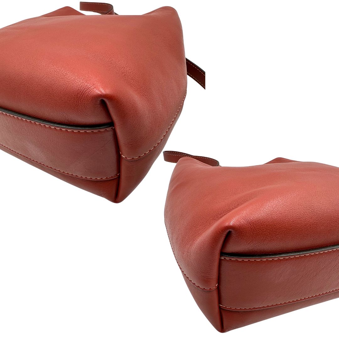 Angoli di una borsa a secchiello Hags in pelle color marrone bruciato con manico regolabile. Parti metalliche argentate. Indossabile a spalla o a tracolla. Completa di dustbag.