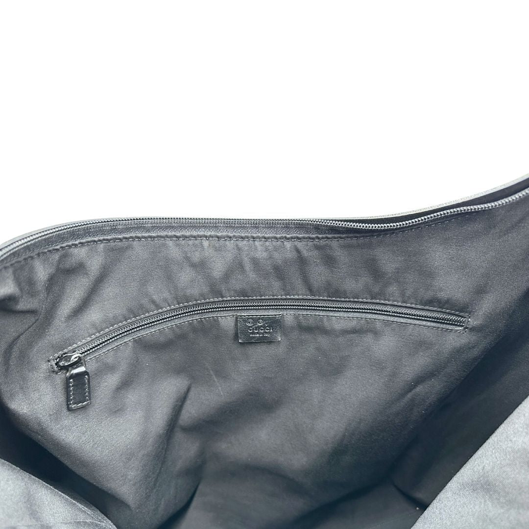 Interno di un borsone Gucci in tessuto trama GG Supreme con parti metalliche argentate e finiture in pelle tono su tono; munita di un manico singolo amovibile. Indossabile a spalla.