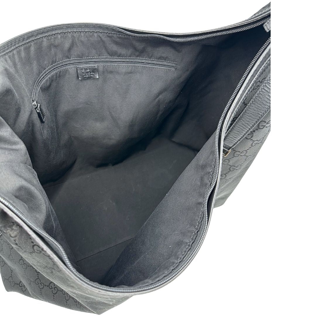 Interno di un borsone Gucci in tessuto trama GG Supreme con parti metalliche argentate e finiture in pelle tono su tono; munita di un manico singolo amovibile. Indossabile a spalla.