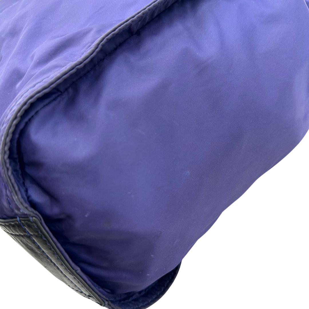 Borsa Burberry Tote Buckleigh in nylon viola con finiture in pelle nera e parti metalliche effetto renio. Munita di doppi manici, da indossare a spalla. Originale, usato, in condizioni ottime. 